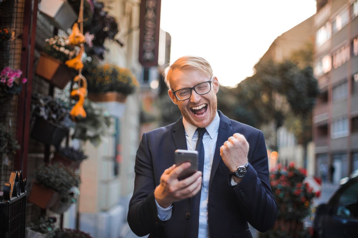 Man celebrating a deal alert on his phone