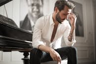 Dramatic tattooed male sitting at piano