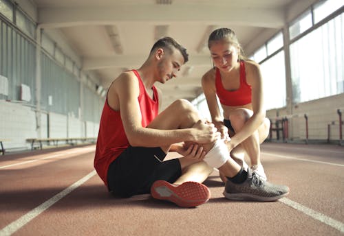 有酸素運動中に怪我をしてスポーツマンを助ける女性