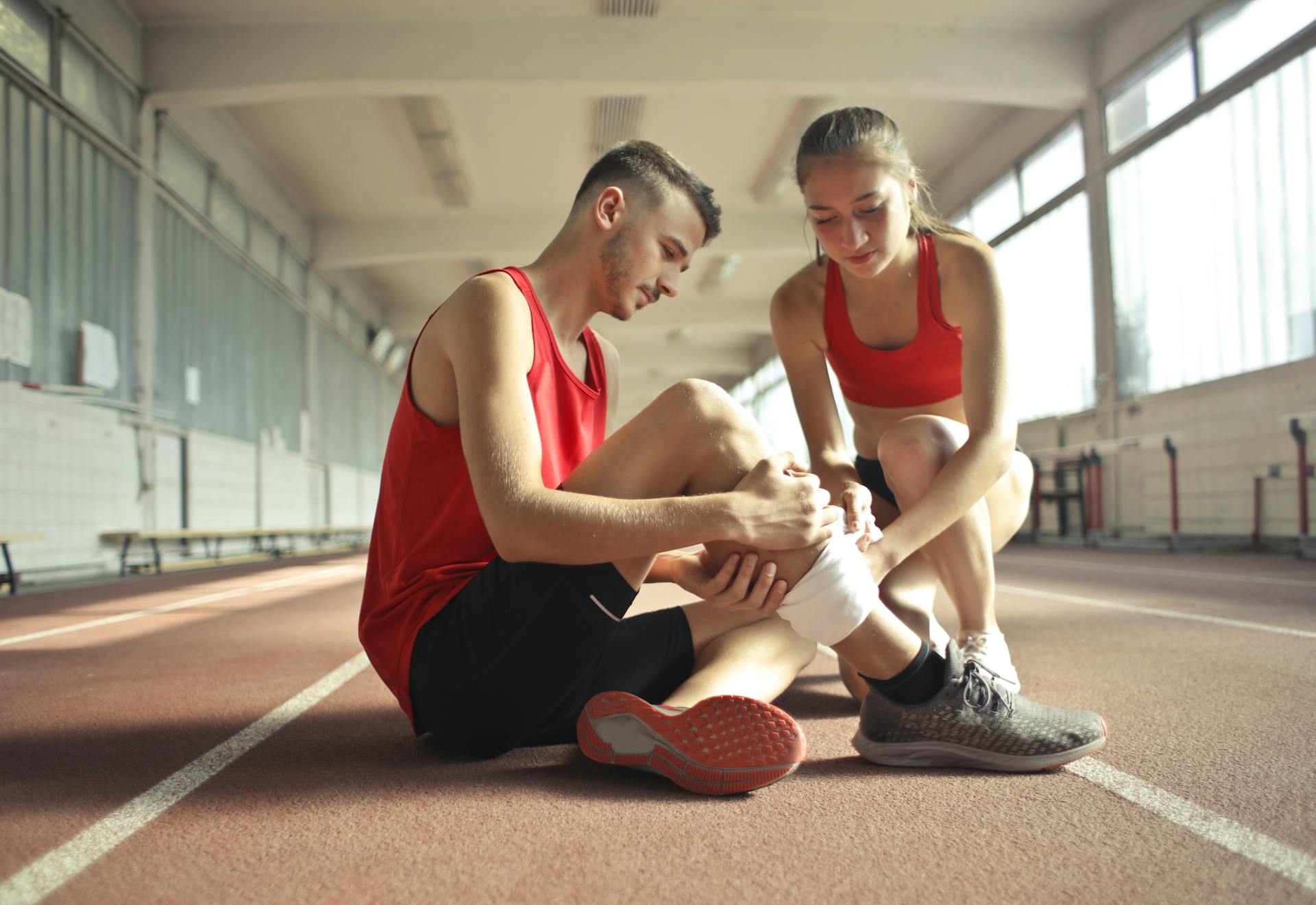 Woman Wrapping Man's Leg with Bandage