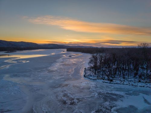 Free Aerial view of a serene winter sunset over a frozen river in West Newton, Minnesota. Stock Photo