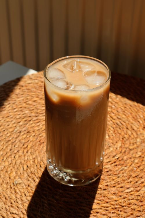 Free A glass of iced coffee with ice cubes on a sunny day. Stock Photo