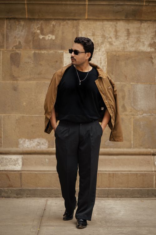 Free Stylish man walking in a city, wearing sunglasses and casual attire. Stock Photo