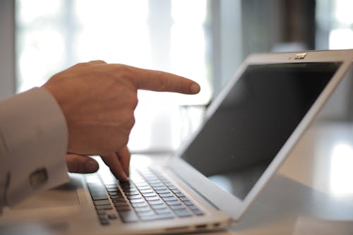 Photo of Person Pointing On Laptop