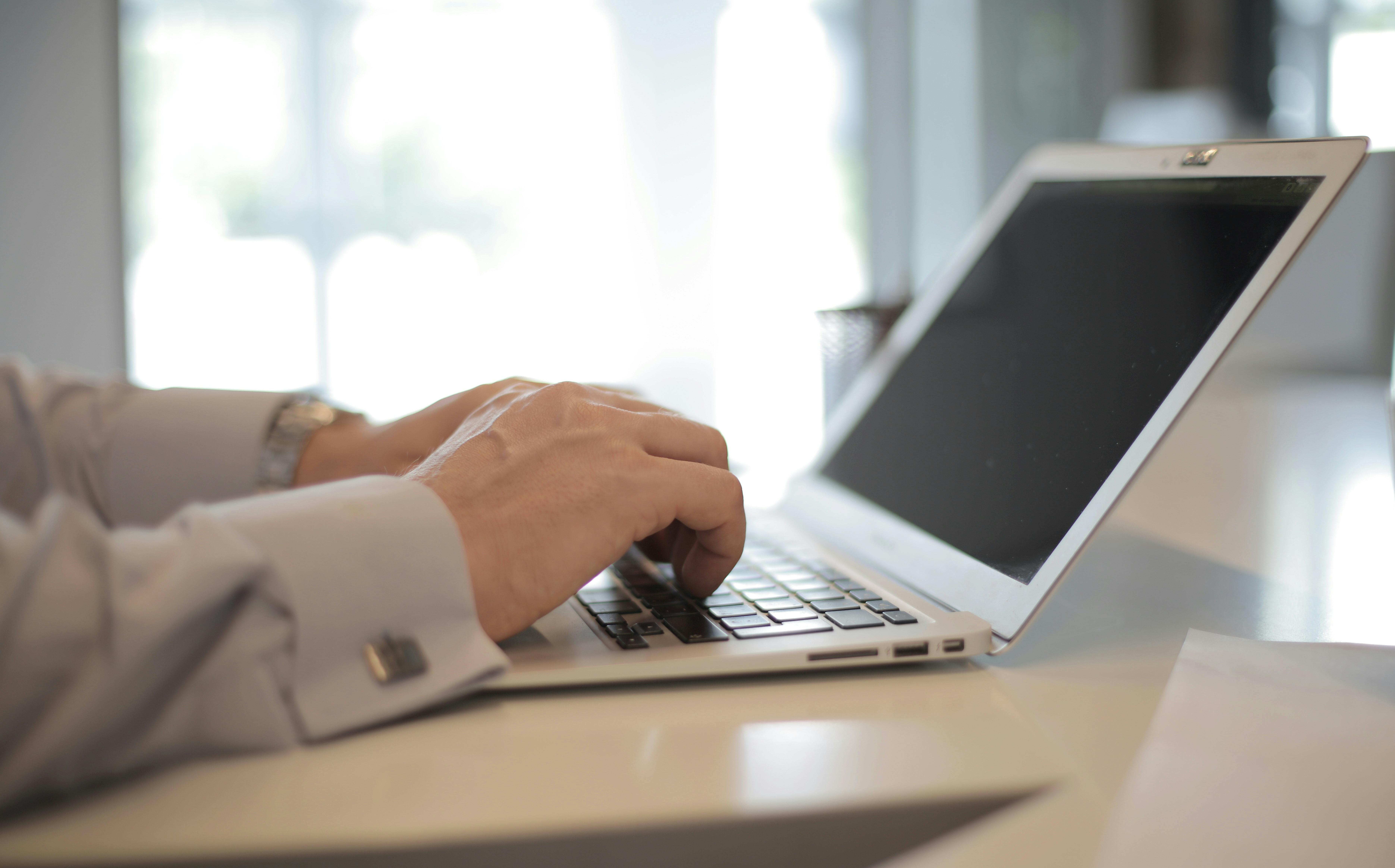 a man using laptop computer on white table