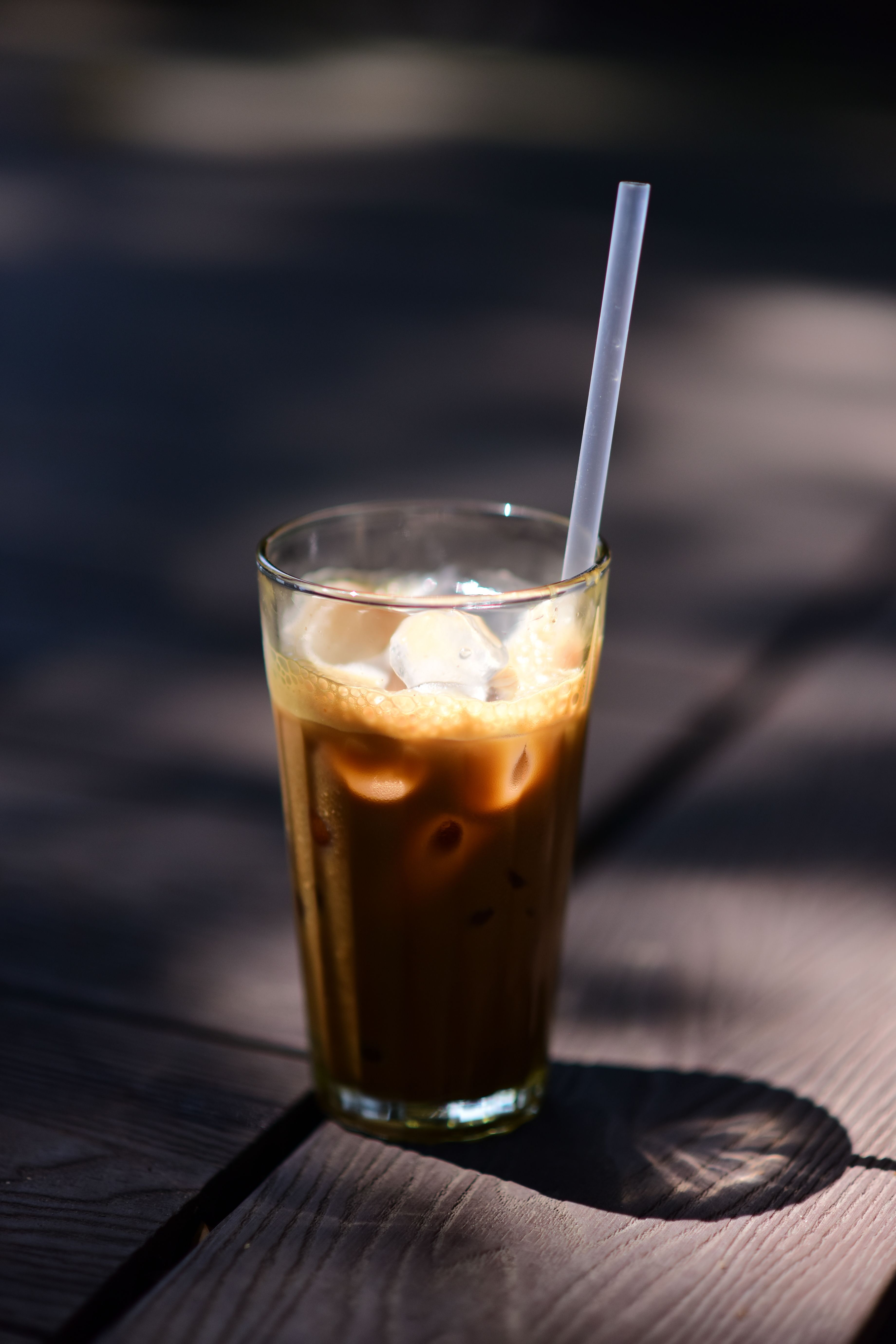 A tall glass of iced coffee with straw, perfect for a warm day.