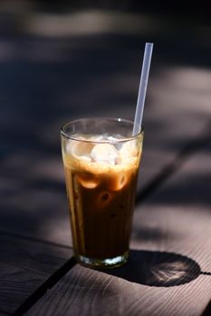 A tall glass of iced coffee with straw, perfect for a warm day.