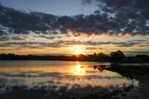Free Breathtaking sunset over a tranquil lake with colorful sky reflections, ideal for peaceful landscape and nature themes. Stock Photo