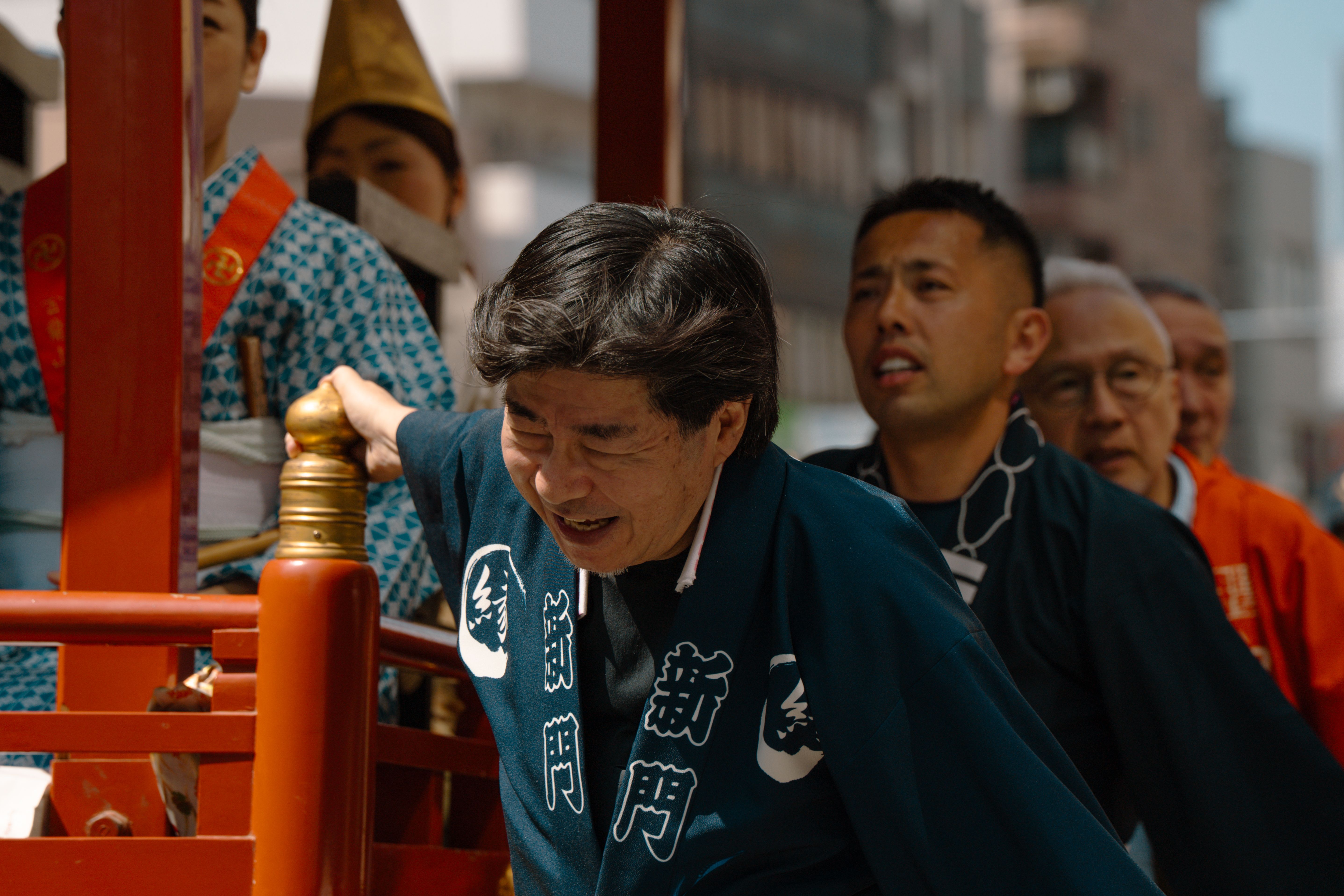 伝統的な衣装を着た男性たちが東京で活気ある祭りのパレードに参加しています。