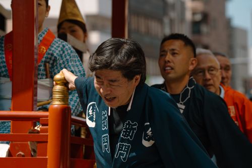Free Men in traditional attire participate in a vibrant festival parade in Tokyo. Stock Photo