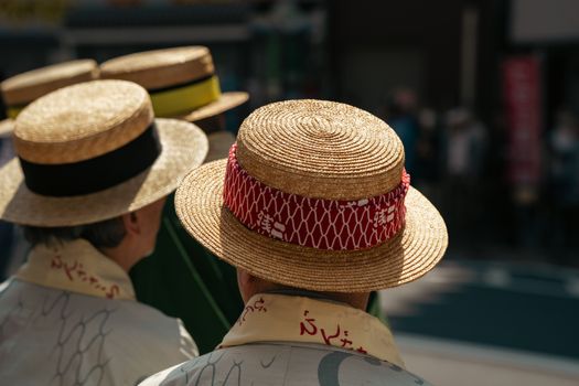 Group of people wearing straw hats at a cultural festival in Tokyo.