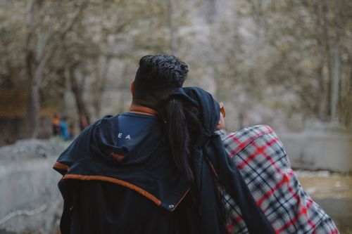 Free A couple embraces while enjoying a scenic autumn view outdoors, showcasing love and nature. Stock Photo