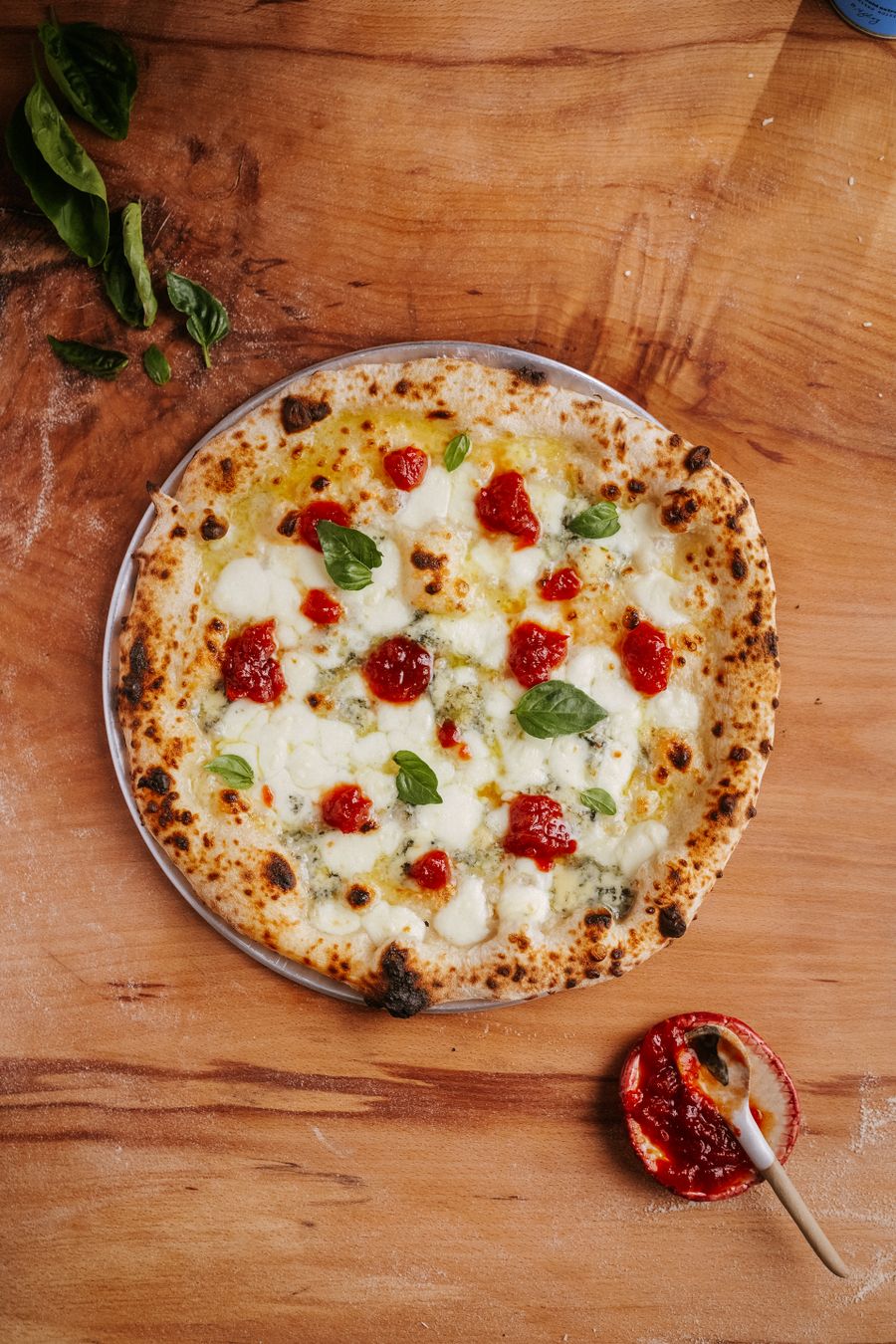 Pizza napolitana vista desde arriba con tomate cherry y albahaca