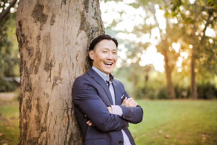 Photo Of Man Leaning On Tree Trunk