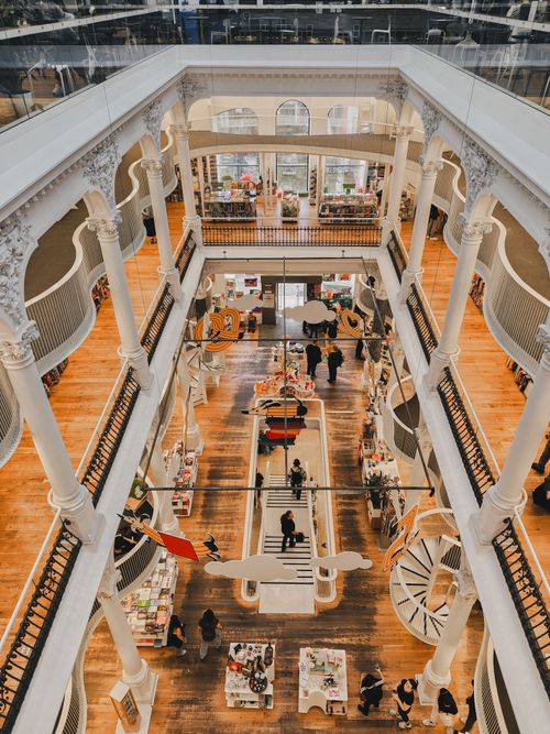 Free A breathtaking view of a multi-level library in Bucharest, Romania, bustling with visitors. Stock Photo