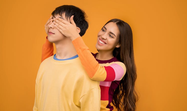 Woman Covering Mans Eyes From Behind