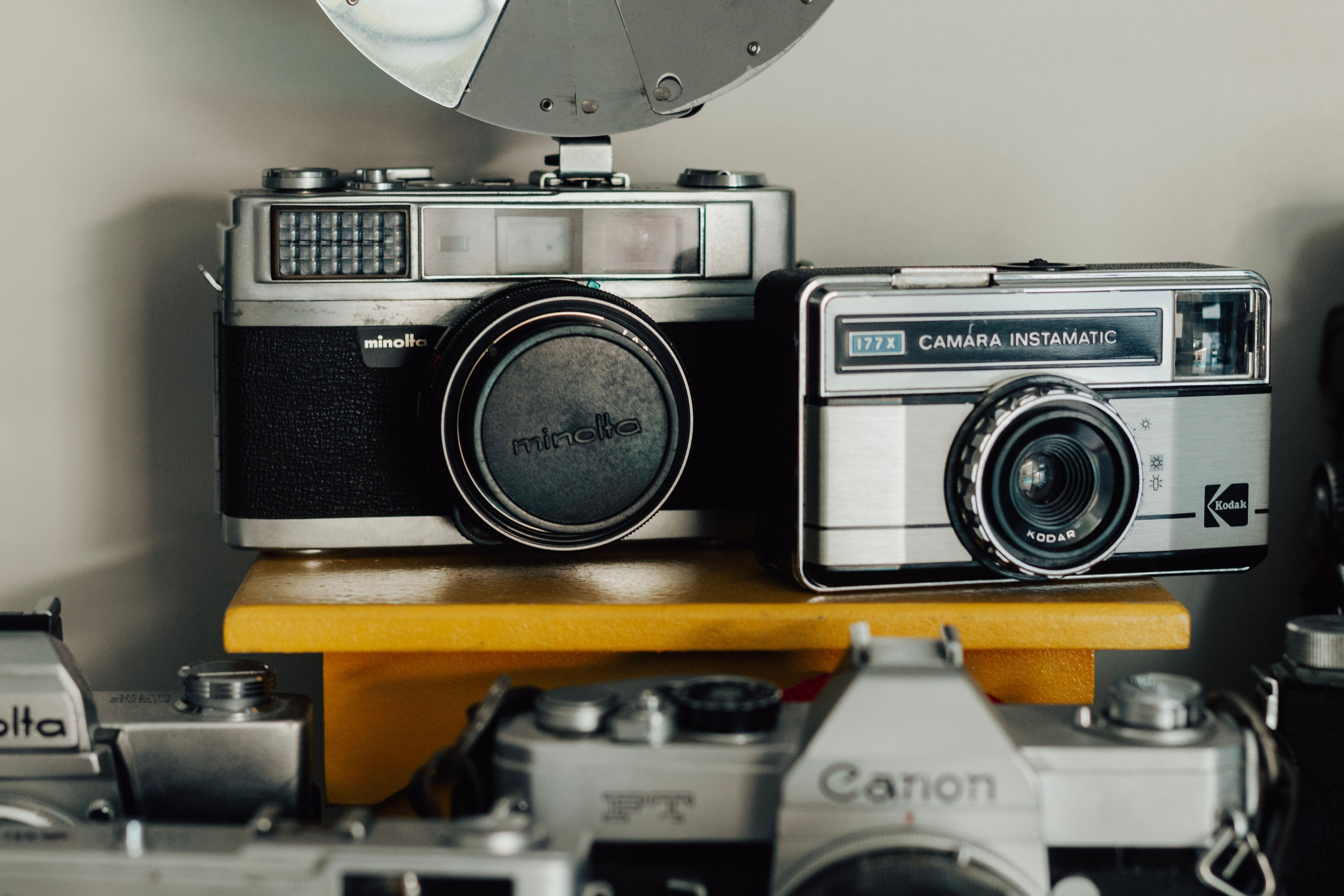 A collection of vintage film cameras featuring Minolta and Kodak models on display.