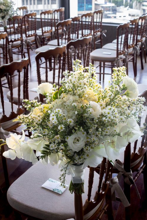 Free Beautiful white flower arrangement at a wedding venue in São Paulo, Brazil with elegant wooden chairs in the background. Stock Photo