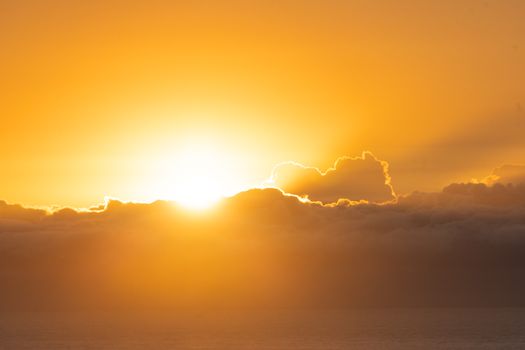 Breathtaking sunrise casting a warm glow over a cloudy horizon, perfect for nature lovers.