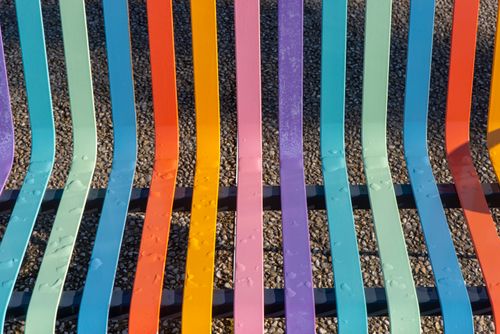 Free Colorful metal bench with raindrops on gravel background, vibrant and inviting. Stock Photo