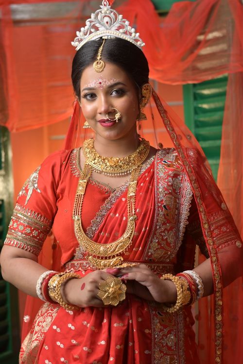 Free Elegant portrait of a Bengali bride in traditional red attire and jewelry. Stock Photo