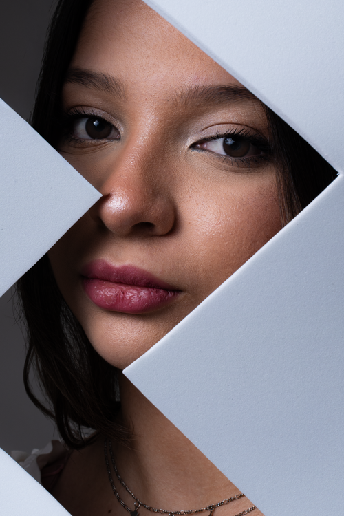 Free Close-up portrait of a woman framed by geometric shapes, capturing an artistic and modern aesthetic. Stock Photo