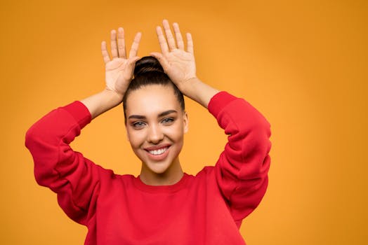 一位年轻女子身着红色毛衣，在黄色背景前嬉戏摆姿，充满活力的肖像