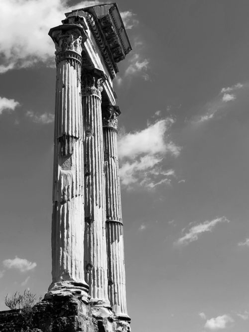 Free Black and white photo of ancient Roman columns against a cloudy sky. Stock Photo