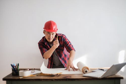 Free Man in Red and Black Shirt Wearing Red Hard Hat Stock Photo