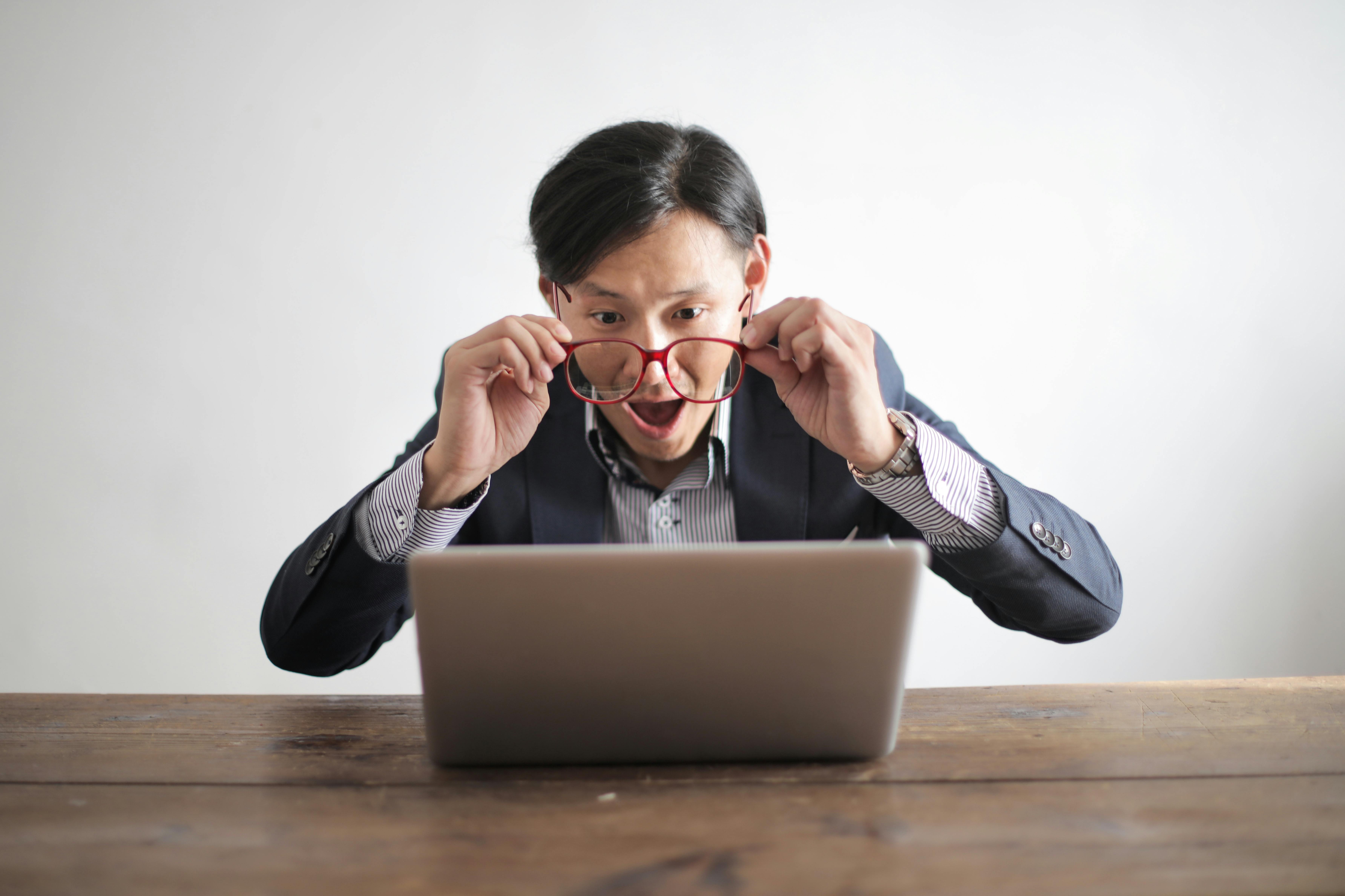 Surprised man looking at laptop.