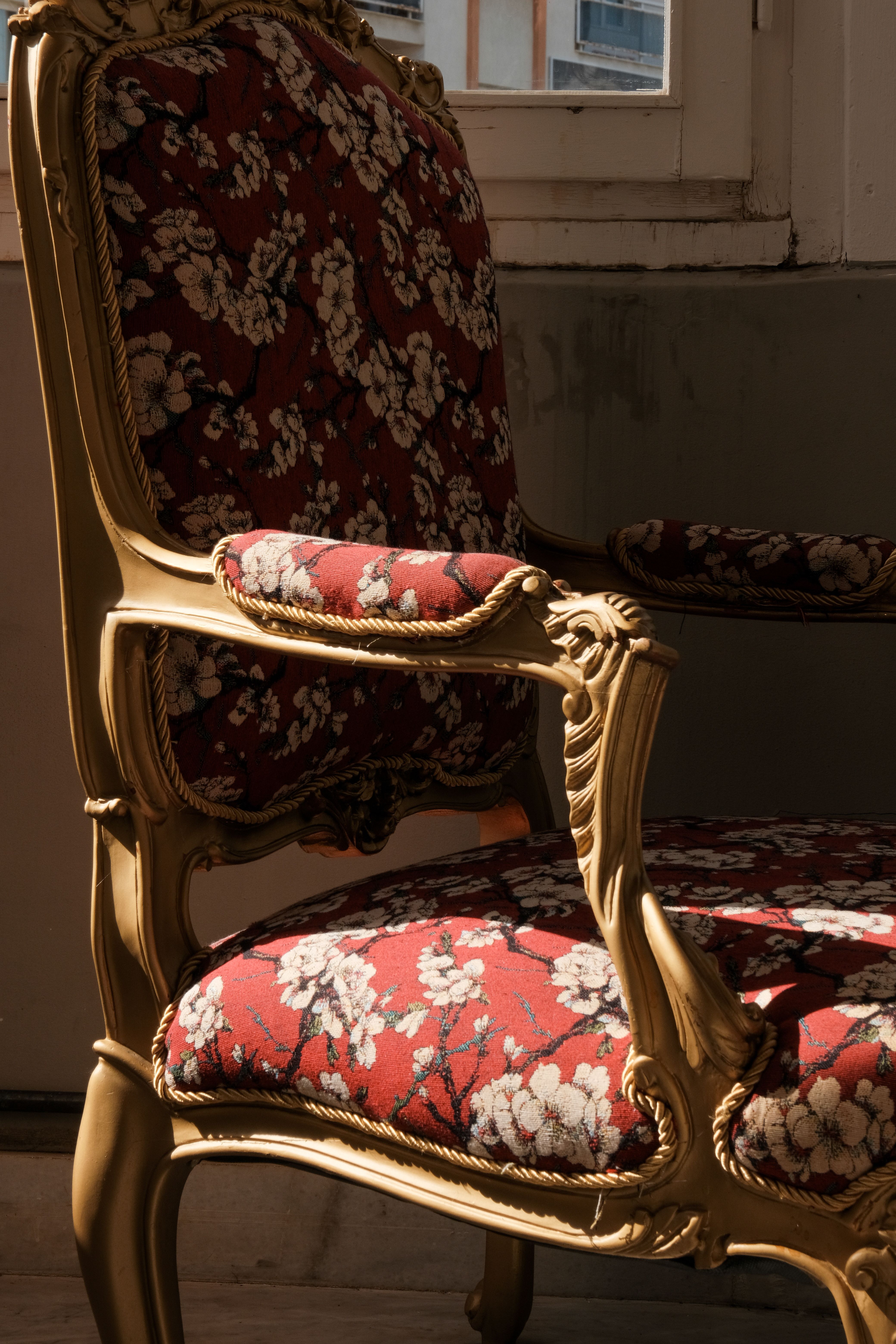 Reupholstery in Denver, CO with a vintage floral armchair in warm sunlight by a window