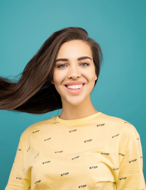 무료 노란색 셔츠에 웃는 여자의 사진 스톡 사진