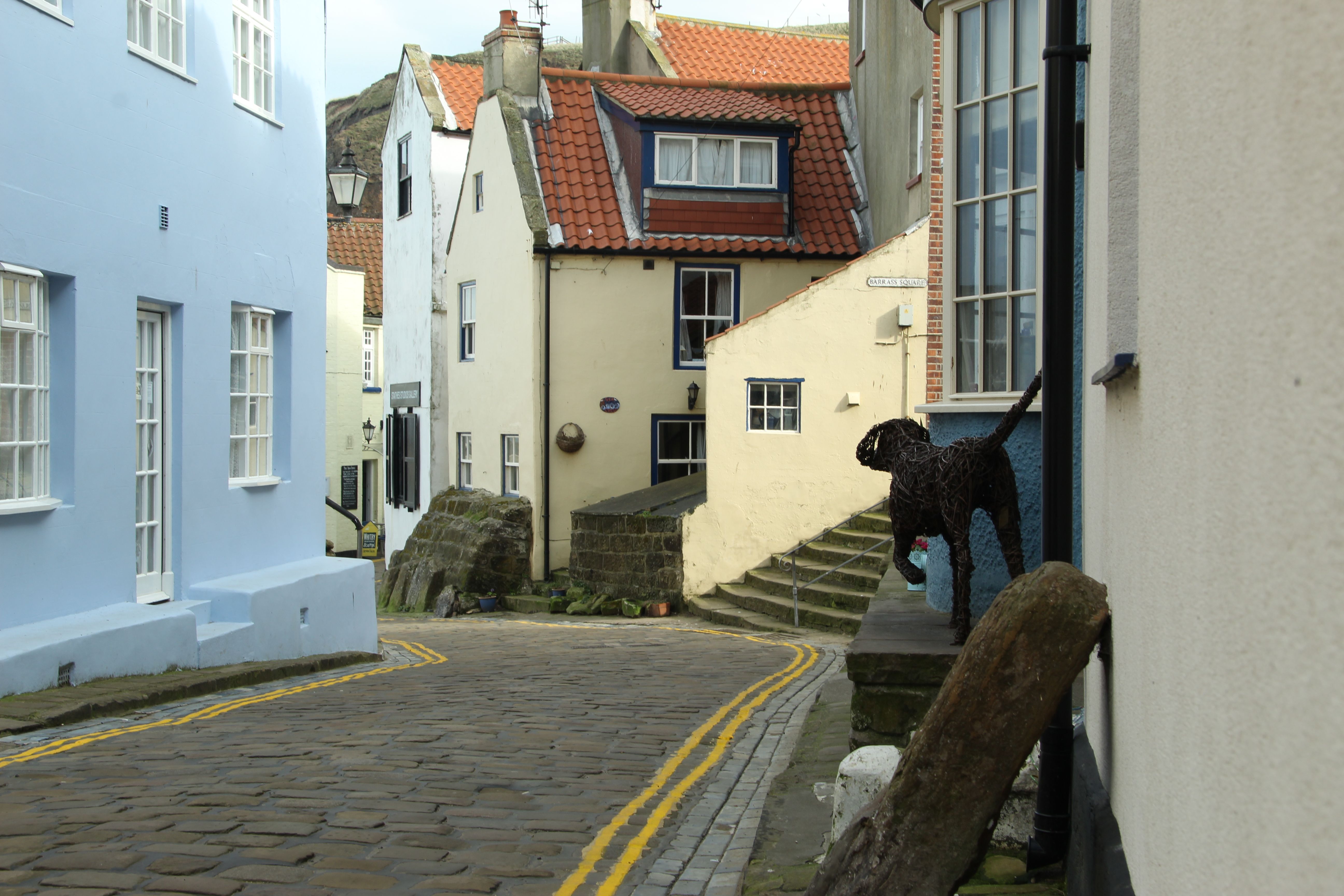 Red-roofed cottages stacked down the ravine at Robin Hood's Bay with the slipway and shore below