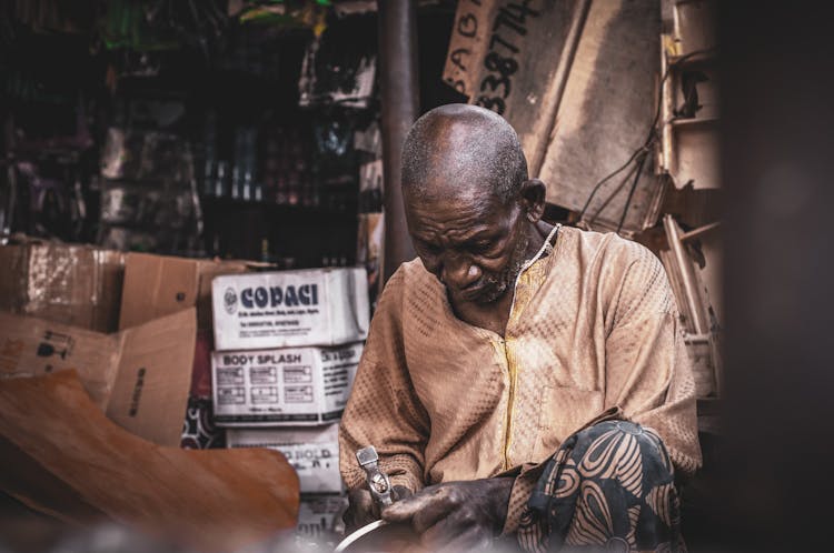 Focused Senior Black Man Using Hummer In Workshop