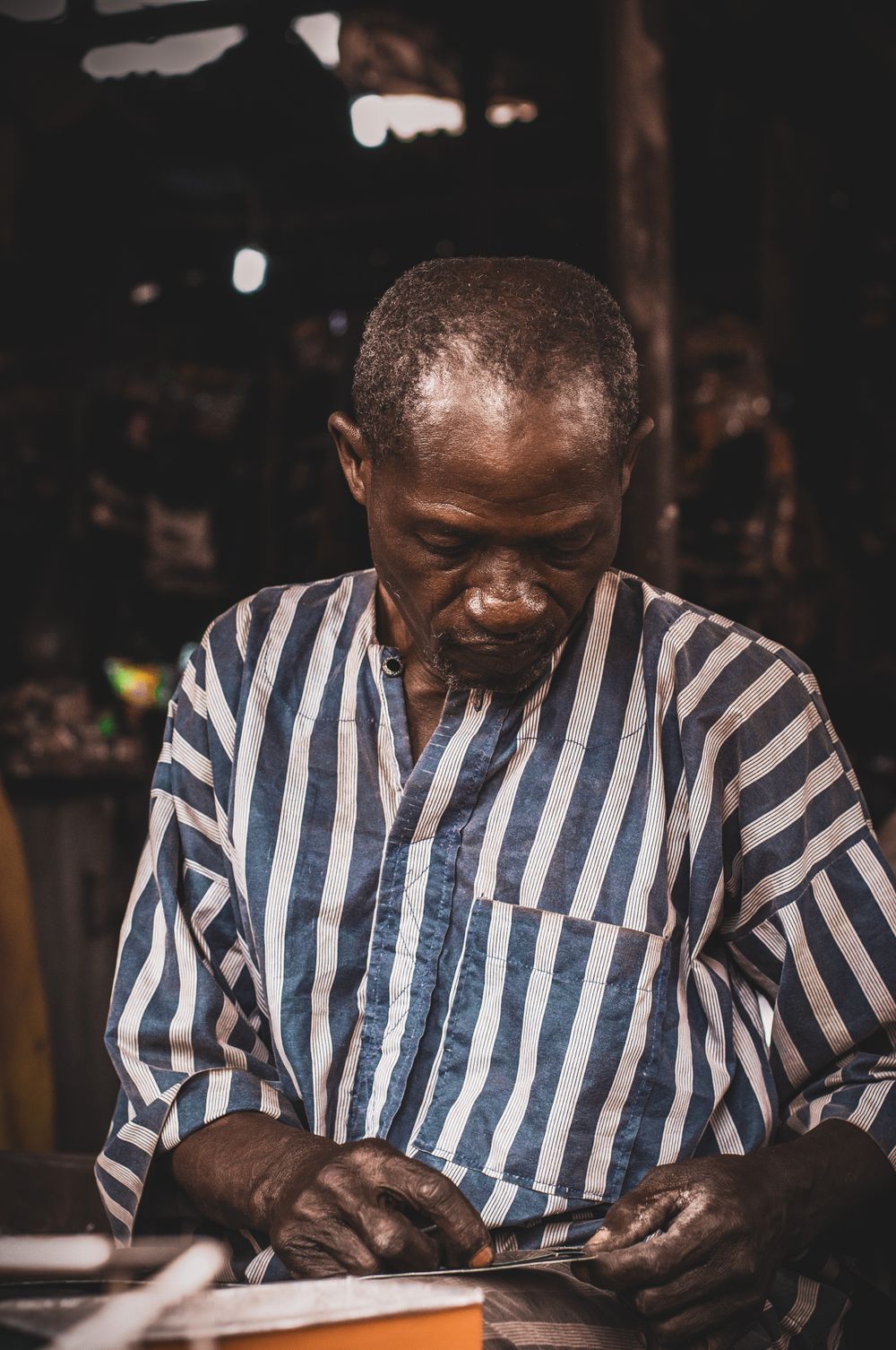 Tradesman working a length of steel at a bench in a fabrication shop.