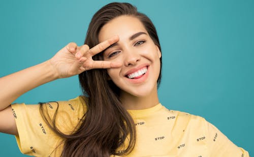 Vrouw In Het Gele T Shirt Van De Bemanningshals Het Glimlachen