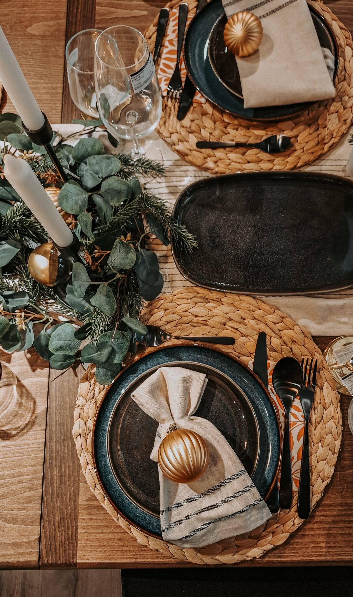 Tall candle-style folded napkin standing at an elegant holiday table