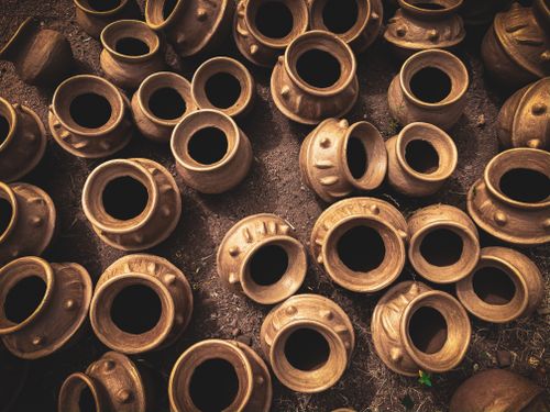 Free From above of various traditional handmade clay pots placed on rough ground in rustic workshop Stock Photo