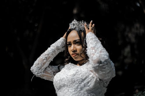 Free Concentrated ethnic woman in wedding dress and crown before ceremony Stock Photo