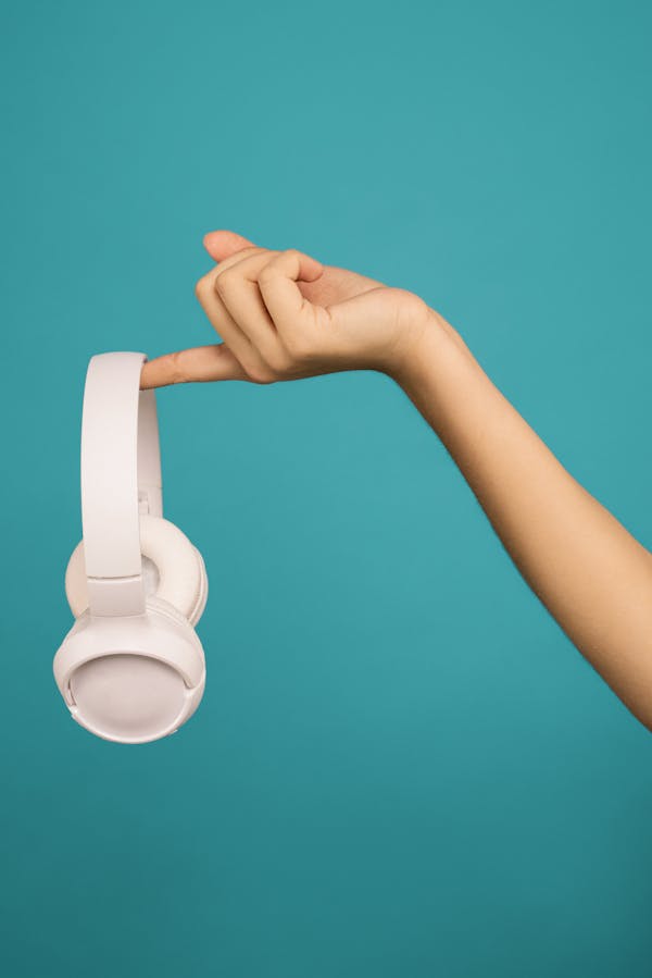 Photo of Person Holding White Headphones