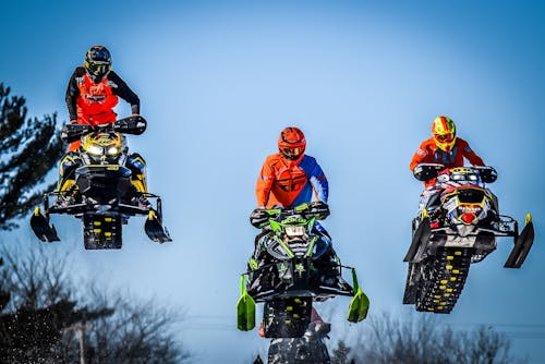 Groep Extreme Liefhebbers Springen Op Sneeuwscooters Op Zonnige Dag