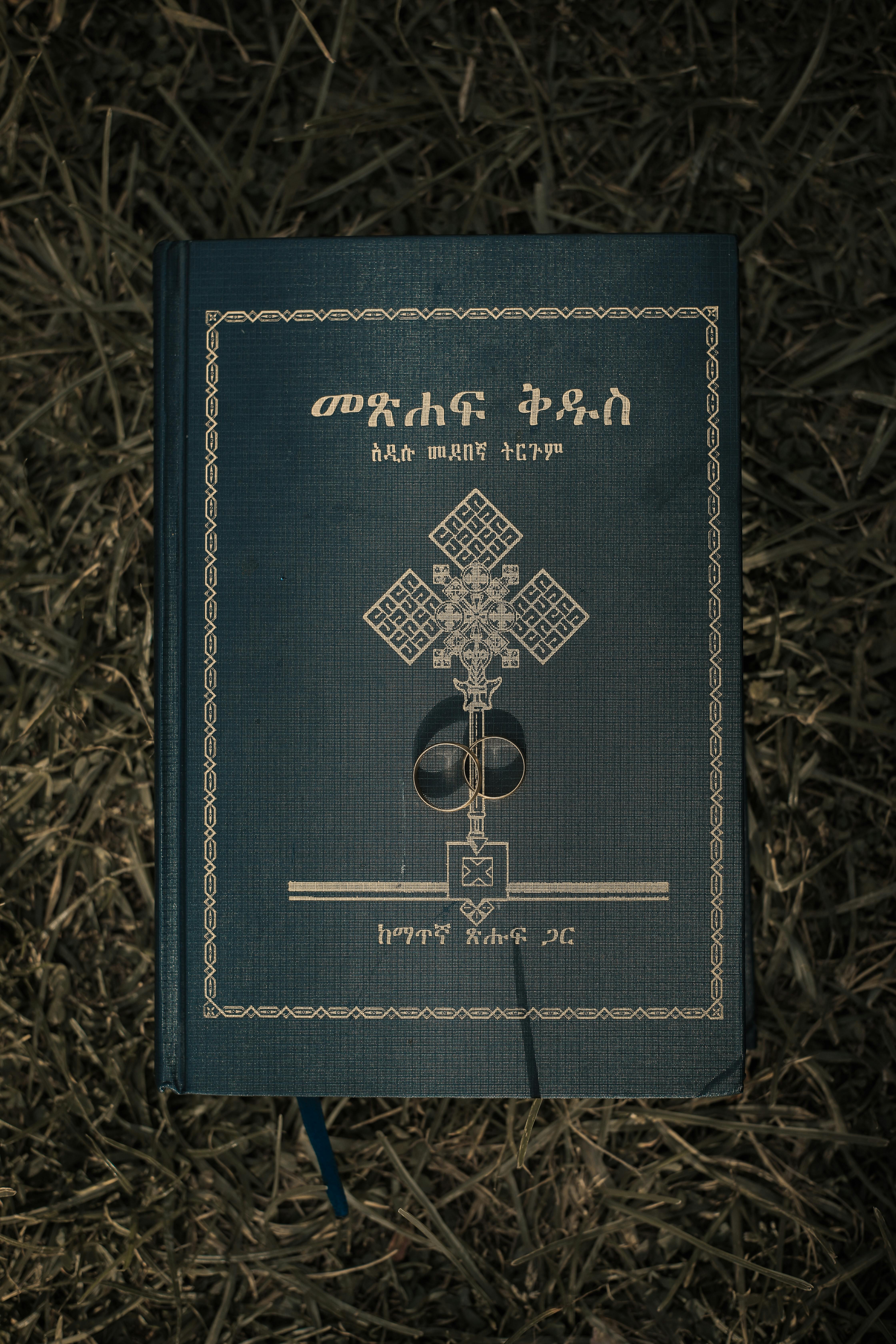 草地上放着一本埃塞俄比亚圣经，封面上搁着一枚结婚戒指