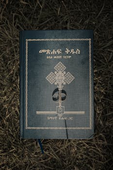 草地上放着一本埃塞俄比亚圣经，封面上搁着一枚结婚戒指