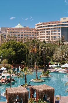 Elegant resort featuring lush gardens, palm trees, and inviting pools under a clear blue sky.