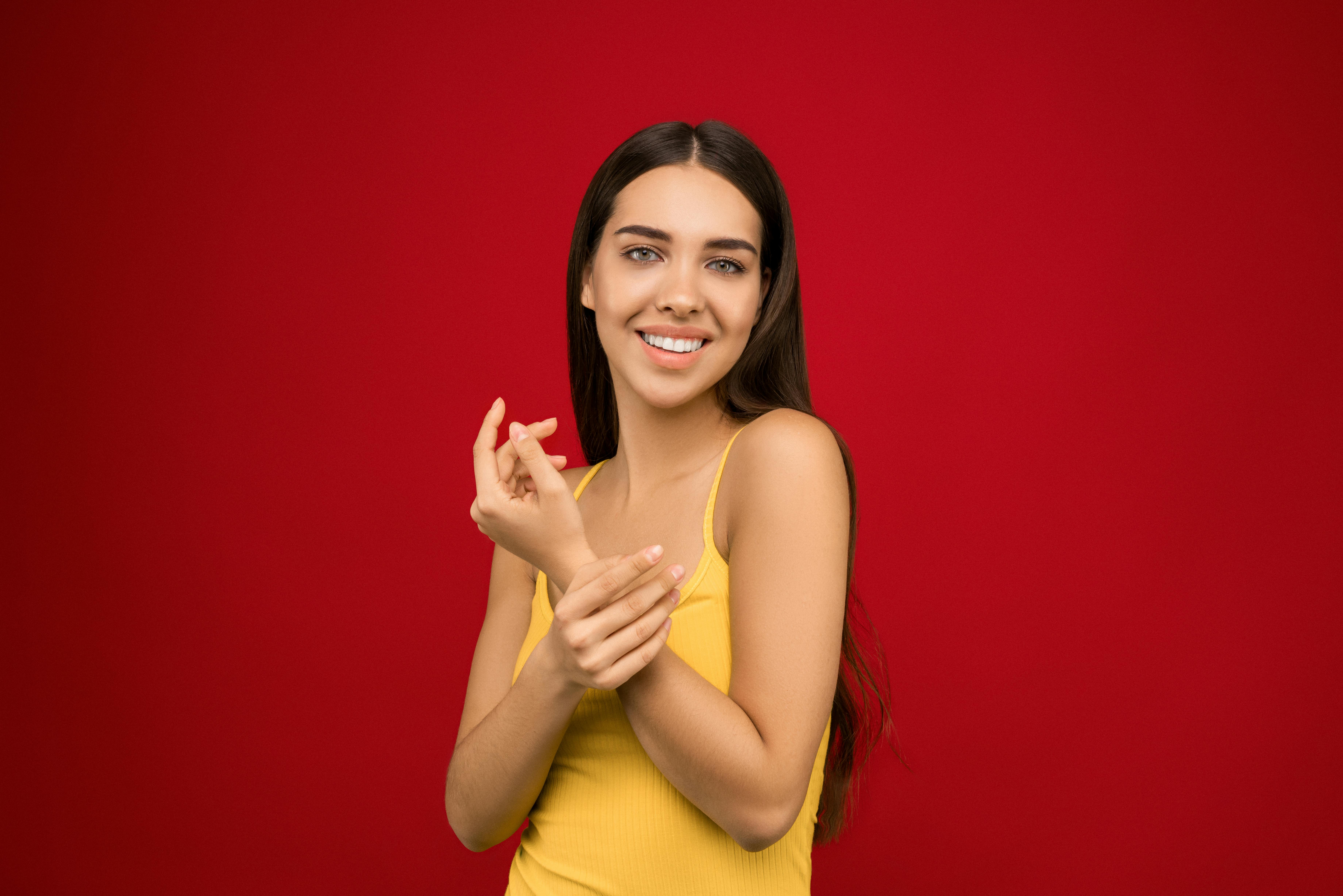 photo of woman smiling in yellow tank top