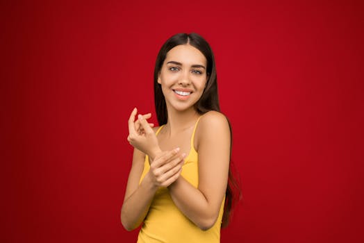 一个开朗的女人穿着黄色背心，在充满活力的红色背景下摆姿势