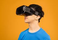 Man in Blue Crew Neck Shirt Wearing Black VR Headset