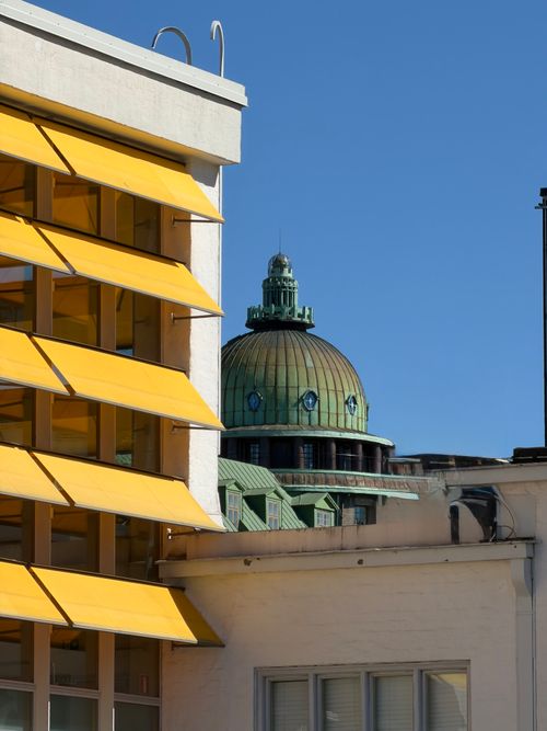 Free Contrast between historic dome and modern architecture with striking yellow awnings. Stock Photo