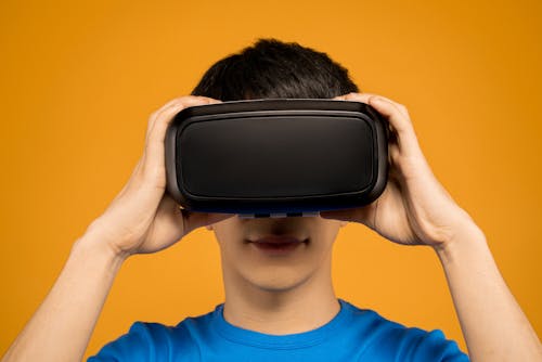 Free Man in Blue Crew Neck Putting on a VR Headset Stock Photo