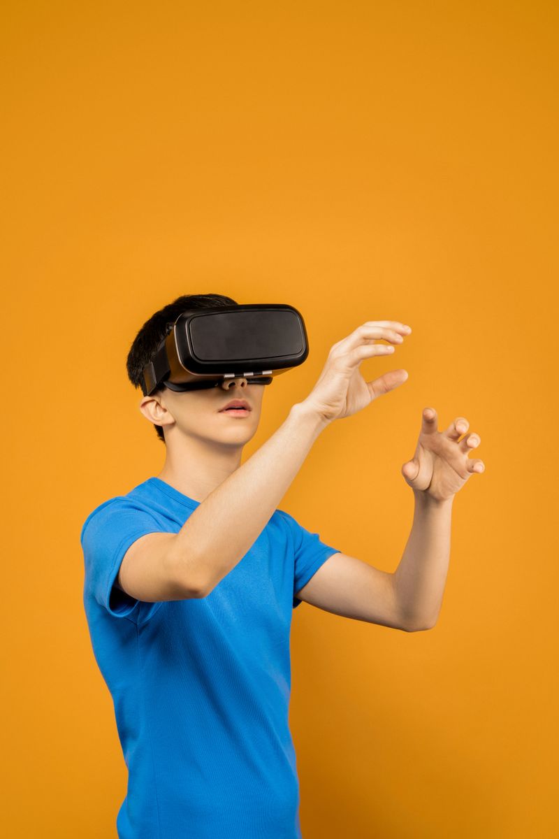 A man in a blue shirt using a virtual reality headset against an orange background.